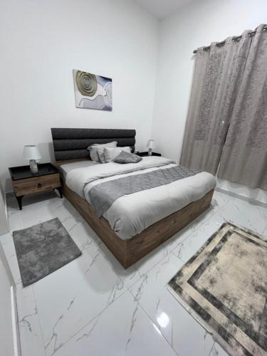 ein weißes Schlafzimmer mit einem Bett und einem Fenster in der Unterkunft Bareeq Rest House in Barka