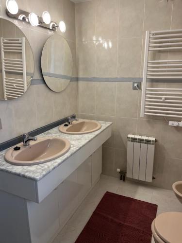 a bathroom with two sinks and two mirrors at Appartement Duplex Rosas avec terrasse magnifique jacuzzi vue mer in Roses