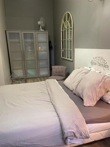 a bedroom with a large bed with white sheets at Le cèdre bleu in Liévin