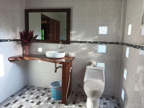 a bathroom with a toilet and a sink and a mirror at Kohjum Freedom Resort in Ko Jum