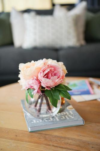 a vase filled with pink flowers on a table at Fabulous River View - Brand New House In Hamilton in Hamilton