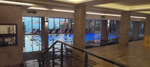 a large swimming pool in a building with columns at Apartman Vana in Kopaonik