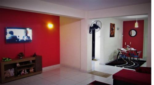sala de estar con paredes rojas y TV en la pared en Rental Furnished Apartment{ Two Bed Room }, en Kisumu