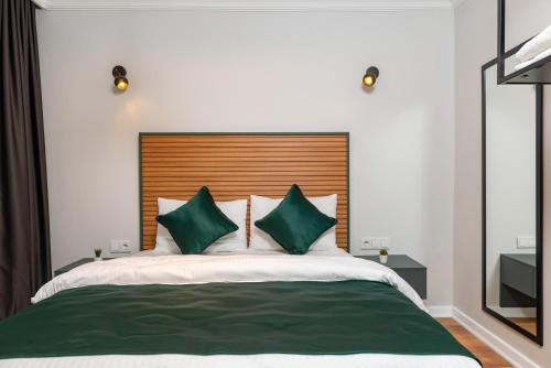 sypialnia z dużym łóżkiem z zielonymi poduszkami w obiekcie G&B MANSION w Stambule