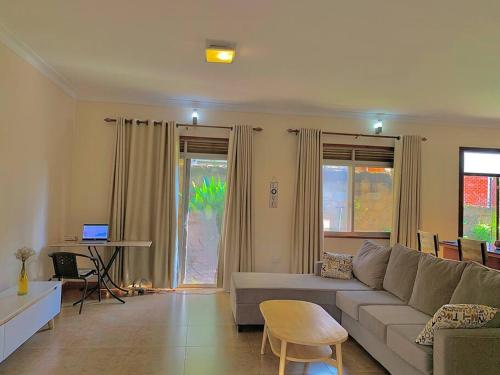 ein Wohnzimmer mit einem Sofa und einem Tisch in der Unterkunft House in Kampala in Kampala