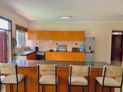 a kitchen with a counter with chairs and a counter top at House in Kampala in Kampala