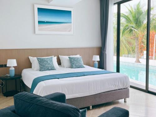 a bedroom with a bed and a swimming pool at Sand Dance Hotel in Prachuap Khiri Khan