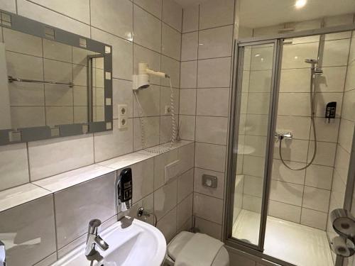 een badkamer met een douche, een wastafel en een toilet bij WestEnd#106 in Frankfurt am Main