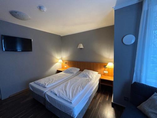 een slaapkamer met een bed en een flatscreen-tv bij WestEnd#106 in Frankfurt am Main