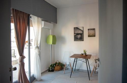 une chambre avec une table, une lampe et une fenêtre dans l'établissement Neapolis apt lycabetus view, à Athènes