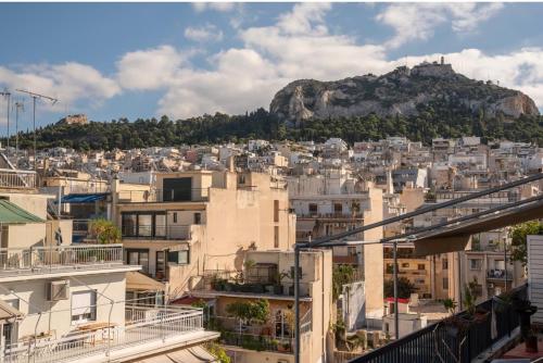 vistas a una ciudad con una montaña en el fondo en Neapolis apt lycabetus view en Athens