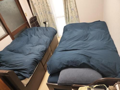 two twin beds in a room with a window at MINPAKU-P 民泊p in Izumi-Sano