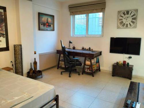 a room with a desk and a television and a bed at Studio Melissi Korinthias in Melíssion