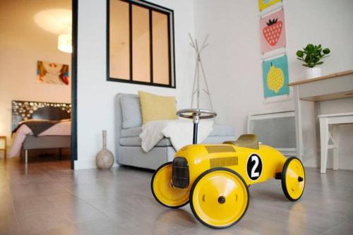 a yellow train toy sitting on the floor in a living room at Le gite des bulles, parking gratuit privatif, centre de Vannes in Vannes