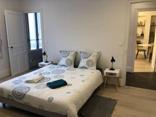 ein Schlafzimmer mit einem großen Bett mit blau-weißer Bettwäsche in der Unterkunft L'Ecrin de Lena in Épernay