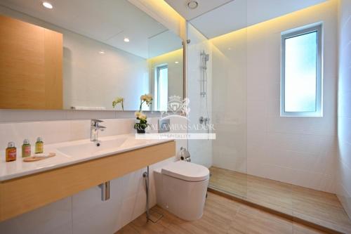 uma casa de banho branca com um lavatório e um WC em Springfield Suites em Seef
