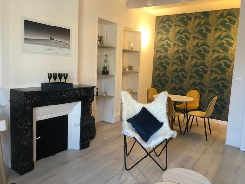 ein Wohnzimmer mit Kamin, Tisch und Stühlen in der Unterkunft L'Ecrin de Lena in Épernay