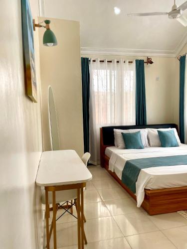 a bedroom with a bed and a table in it at Mudzini gardens - Luxury villa with a pool in Mombasa
