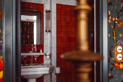 a bathroom with a sink and a toilet and a mirror at Hôtel Eldorado Paris in Paris