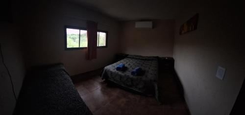 Habitación pequeña con cama y ventana en Los Frutales en Villa Carlos Paz