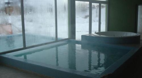 una piscina con bañera en una habitación en Latitud Catedral Apartamento en San Carlos de Bariloche