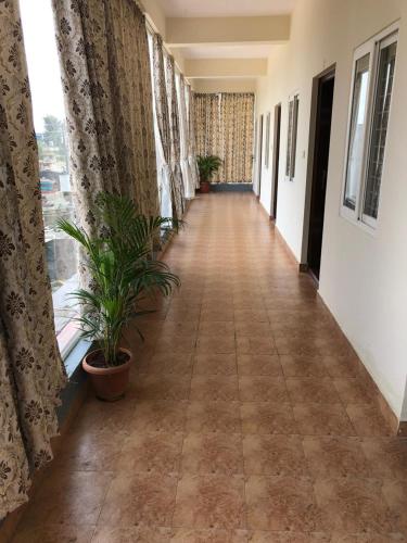 an empty corridor in a building with plants at Hotel Amulya Regency in Bengaluru