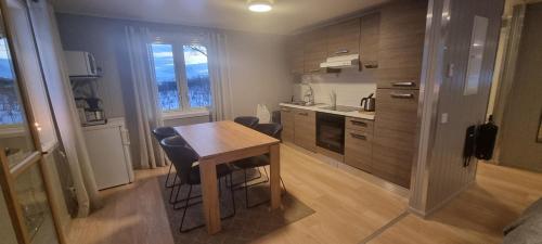 a small kitchen with a wooden table and chairs at Micke o Ritas stuga in Björkliden