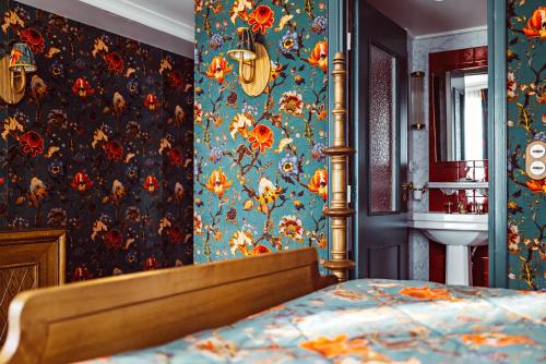 a bedroom with a bed and floral wallpaper at Hôtel Eldorado Paris in Paris