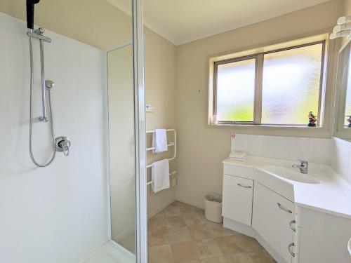 a bathroom with a shower and a sink and a mirror at Perfect for lake view and city view in Rotorua in Rotorua