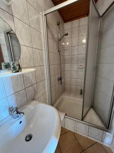 a bathroom with a shower and a sink at Hotel Zur Henne in Schmiedefeld am Rennsteig