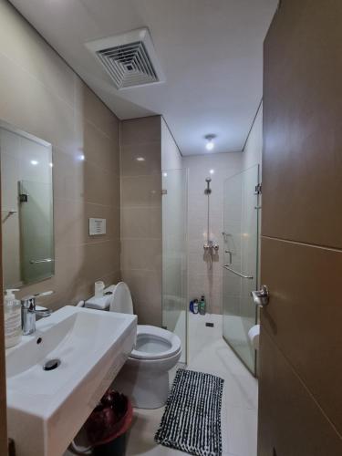 a bathroom with a sink and a toilet and a shower at Palm Tree Condos near MNL Airport Terminal 3 by ELR in Manila