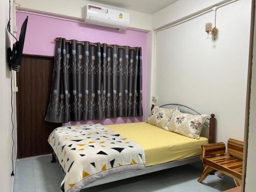 una camera da letto con un letto con una tenda nera di หอพักบ้านชูใจ a Phitsanulok