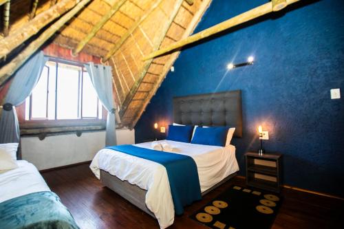 1 dormitorio con 2 camas y pared azul en Koraalboom at Benlize en Hartbeespoort