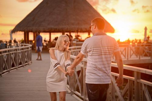 een man en een vrouw die op een pier lopen bij Bandos Maldives in North Male Atoll
