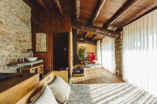 um quarto com uma cama e uma parede de pedra em Mas Redortra Excepcional masía del SXV con vistas al Montseny em Sant Pere de Torelló