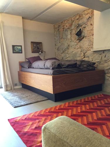 a bed in a room with a stone wall at Im Naturschutzgebiet gelegene Ferienwohnung in Templin
