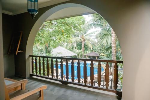 an arched window with a view of a pool at Coconut Lodge Resort in Jepara