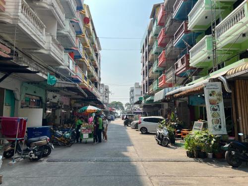 a street with buildings and people standing on the sidewalk at Yuri Guesthouse in Jomtien Beach