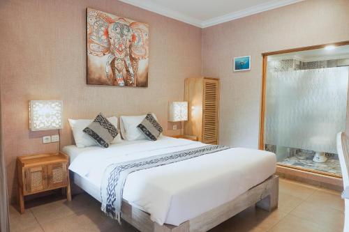 una camera da letto con un grande letto bianco e una finestra di Coconut Lodge Resort a Jepara