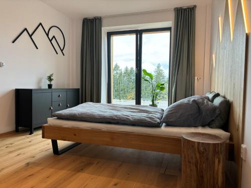 a bedroom with a bed and a large window at ApartBene in Benecko