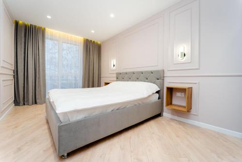 a bedroom with a large bed and a large window at 2BD Buiucani Urban Haven in Chişinău