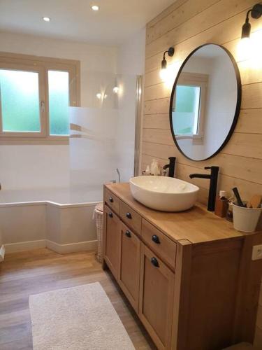 une salle de bain avec un lavabo et un miroir dans l'établissement Maison aux portes de Caen, à Saint-Germain-la-Blanche-Herbe