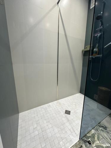 une douche avec une porte vitrée dans une salle de bain dans l'établissement Appartement en Rez de jardin sur la mer, à Menton