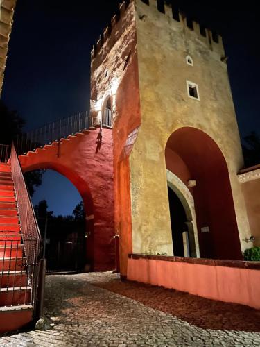 a building with a gate and a bridge at night at Alloggio La Torre Fossanova in Priverno