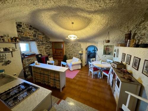 CimbergoにあるAppartamento immerso nel cuore del parco dell Adamelloの石壁のリビングルームとキッチンが備わります。