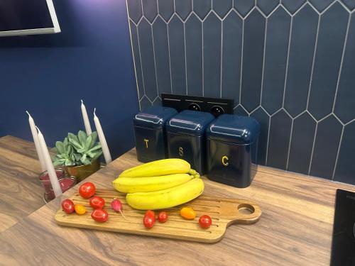 a cutting board with bananas and tomatoes on a table at Silence Hanza Tower Szczecin in Szczecin