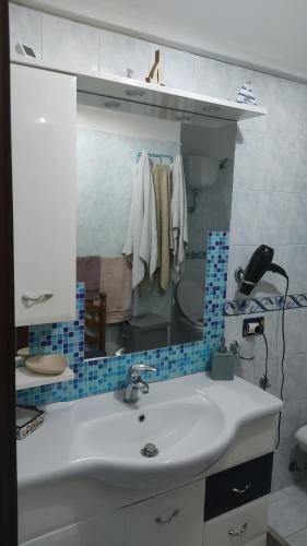 uma casa de banho com um lavatório branco e um espelho. em Villa Giulia al Vesuvio em Trecase