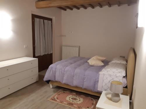 a bedroom with a bed with a purple comforter at Il casale del Trebbio in Pila