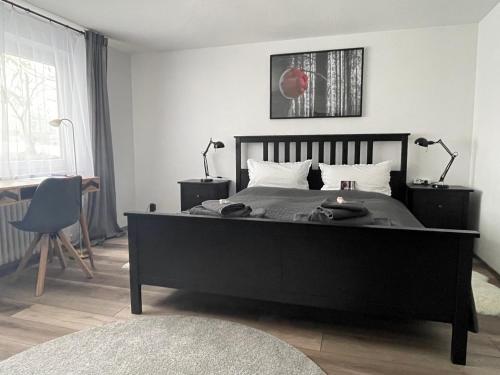 1 dormitorio con 1 cama negra grande y 2 lámparas en Apartment im Gründle, en Birkenfeld