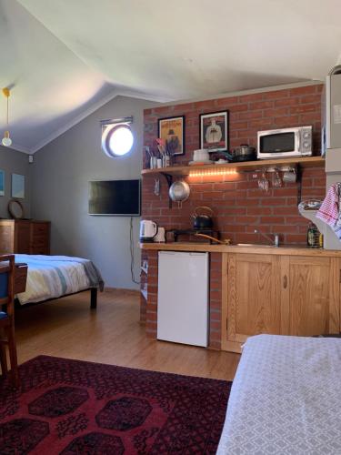 a room with a kitchen and a brick wall at Sapphire Studio in Noordhoek